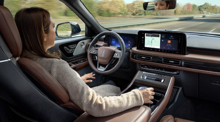 A 2027 Lincoln Aviator® SUV is being driven hands-free on a highway lined with trees. | Dutch Miller Lincoln of Ashland in Ashland KY